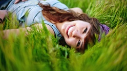 3d обои Улыбающаяся девушка лежит в зеленой траве  2560х1440